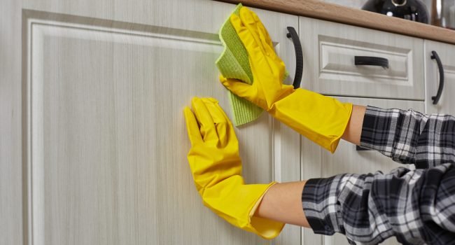 hands-gloves-with-green-rag-is-cleaning-kitchen-cabinets-housework-housekeeping-concept-close-up-scaled.jpg